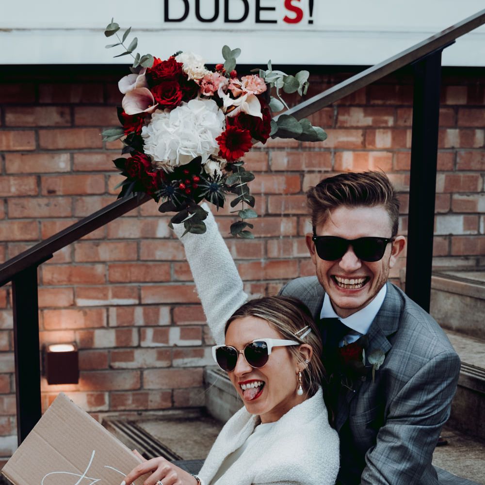 Stylish bride and groom at Manchester micro wedding with cardboard box wedding sign 