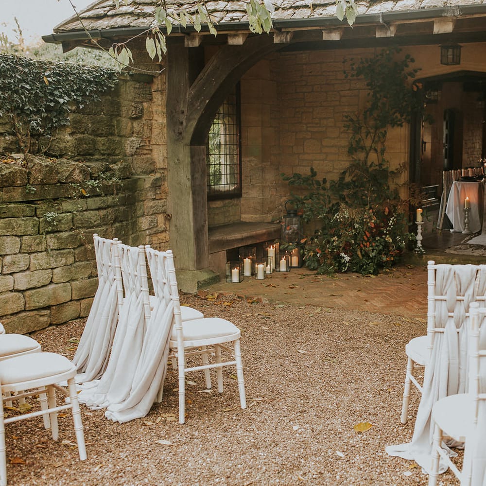 Outdoor wedding ceremony at Hooton Pagnell Hall with fabric chair back decoration