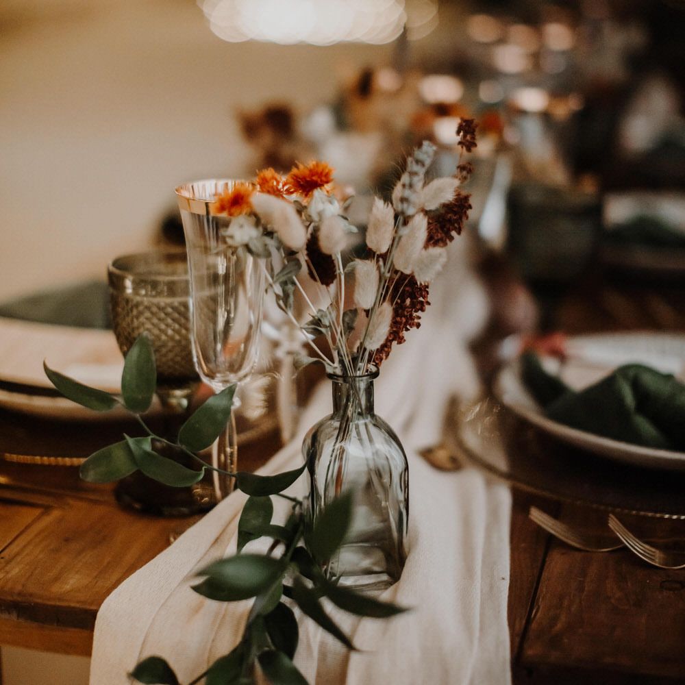 Boho luxe wedding table decor with bud vase and gold rimmed champagne flute