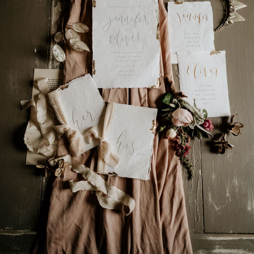 Wedding stationery suite and his and hers vow books tied with dusky pink ribbon 