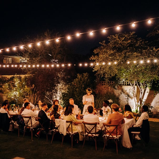 Intimate garden wedding reception with festoon light decor 