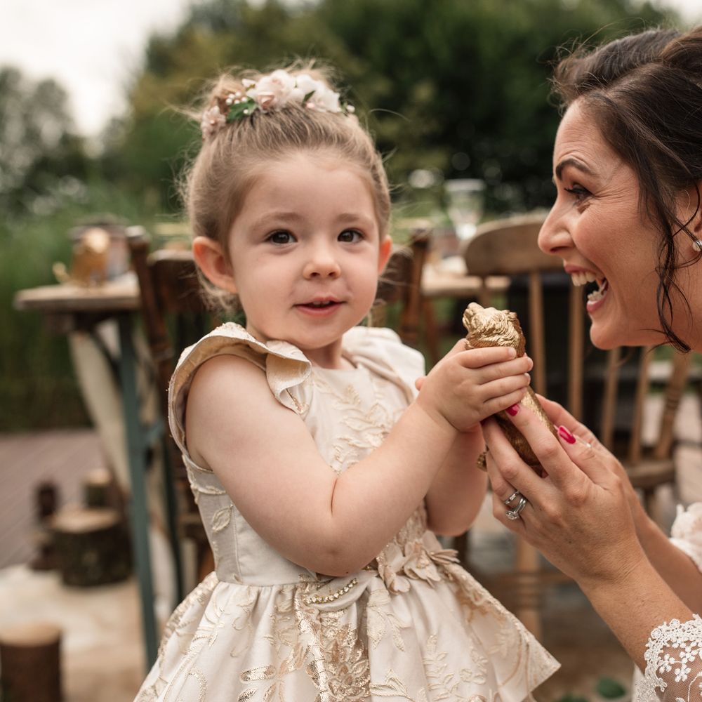 Bride and little girl look at golden ornament 