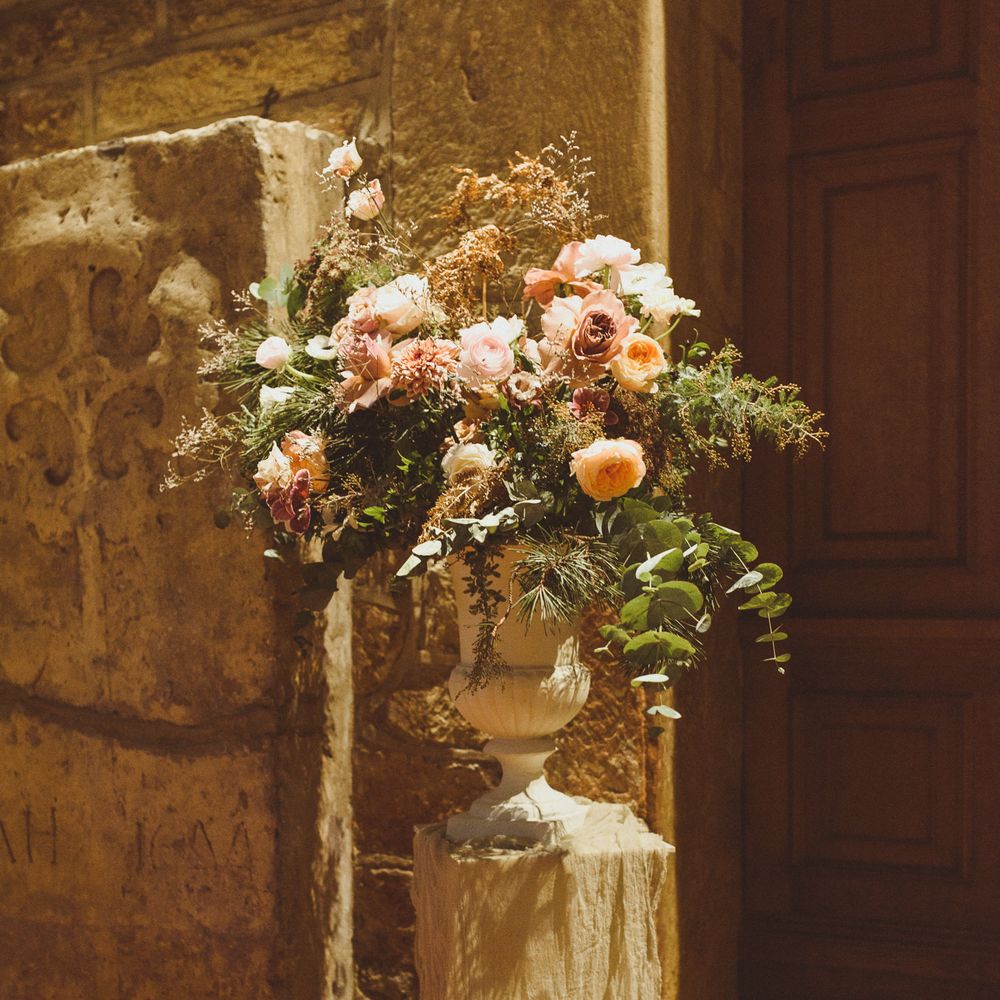 Blush pink urn floral arrangements with foliage 