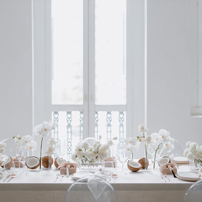 Intimate minimalist wedding table decor with orchid wedding flowers, coconuts and wooden beads