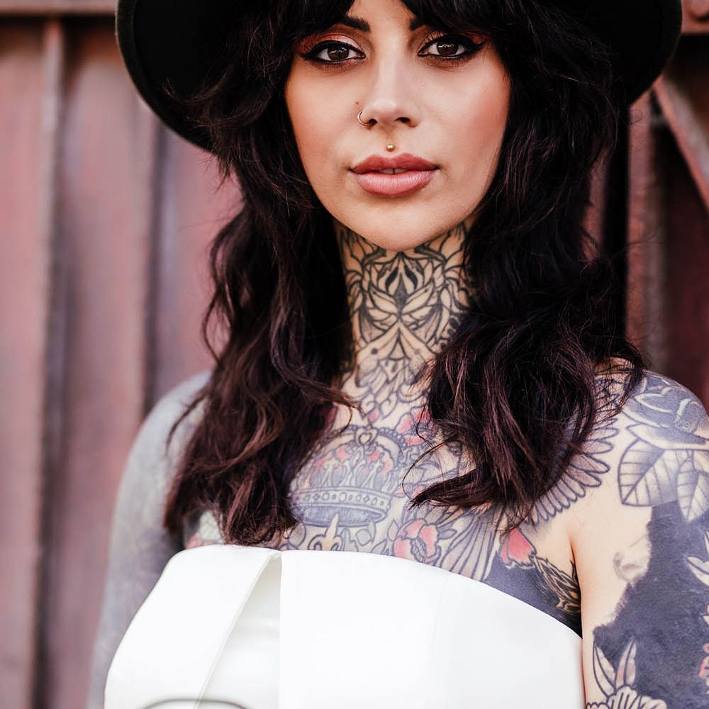 Bride with a fringe wearing a fedora hat showing her smokey eye shadow and eyeliner bridal makeup 