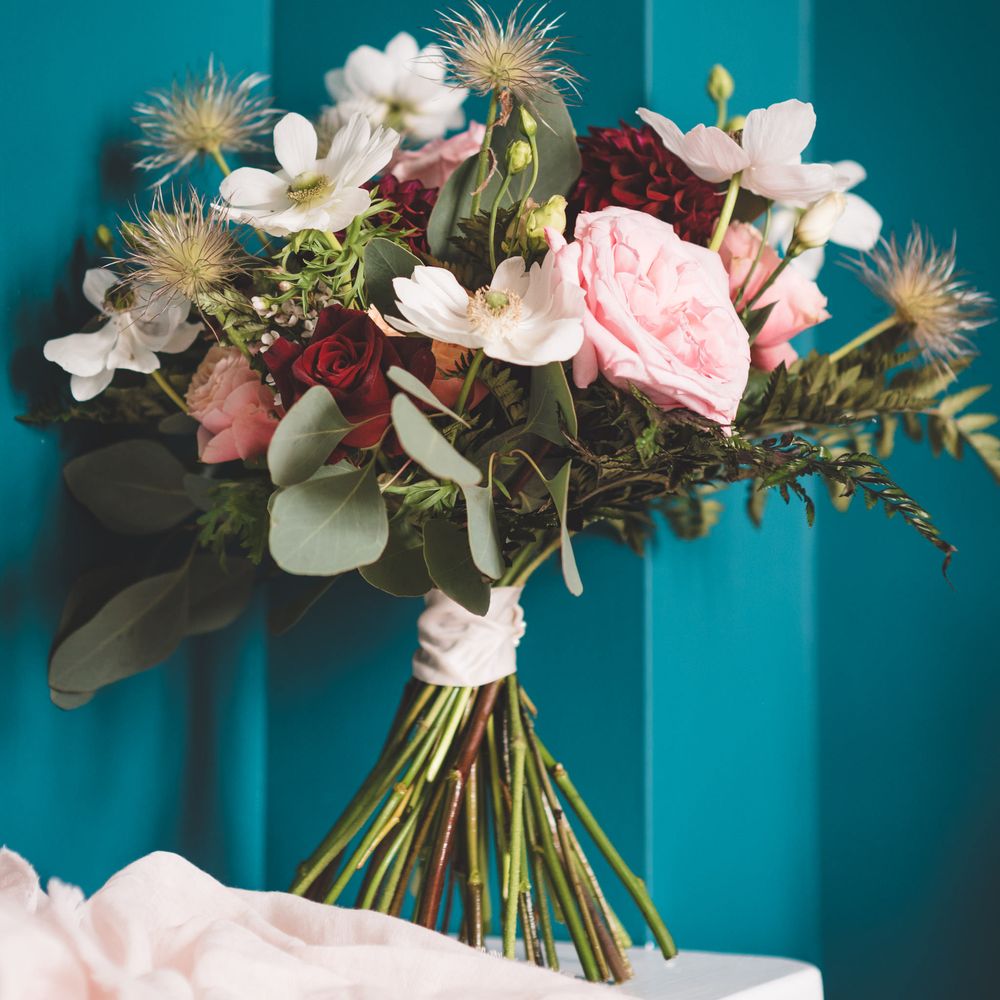 Red, pink, white and green wedding bouquet with dahlias, roses and foliage 
