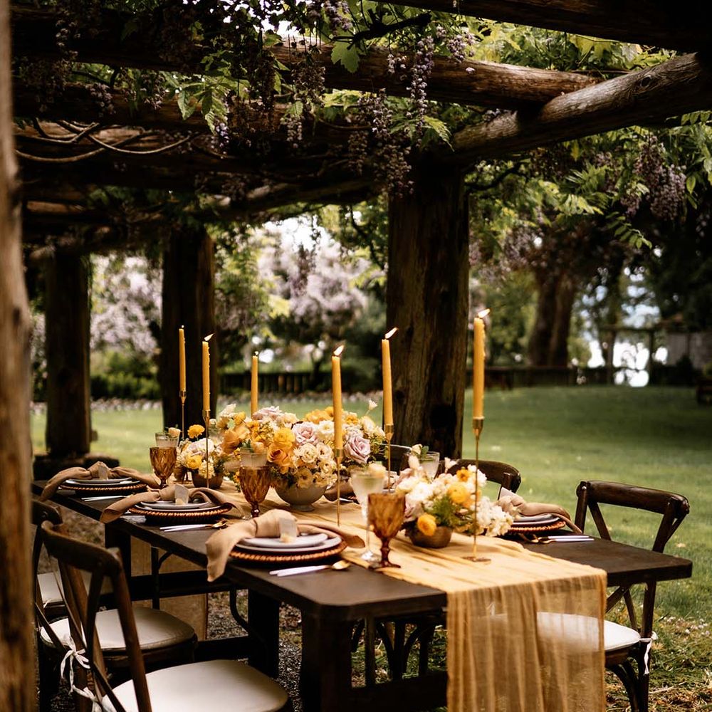 Intimate outdoor wedding reception under a pergola with honey yellow wedding decor and details 