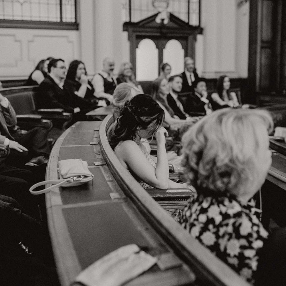 Guest becomes emotional and wipes her eyes during wedding ceremony