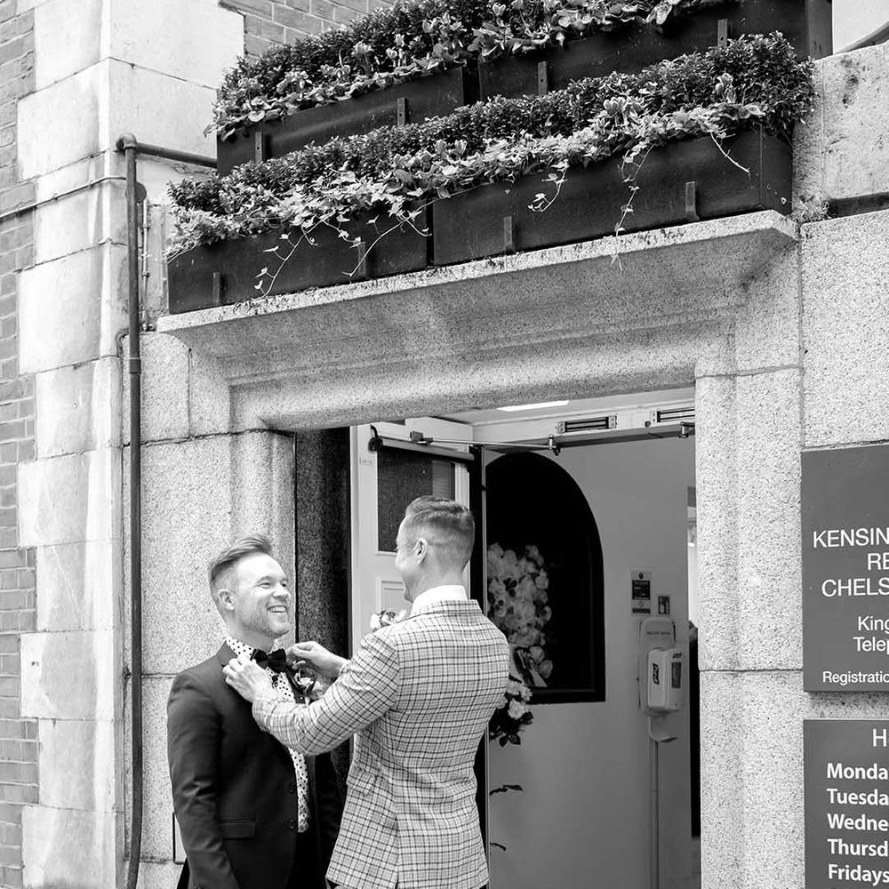 Grooms laugh outside Chelsea Old Town Hall