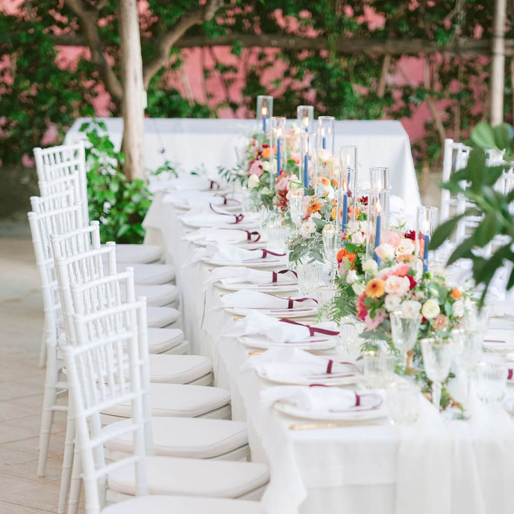 White wedding tablescape for an outdoor Italian LGBTQI+ wedding with tapered candles and floral centrepieces