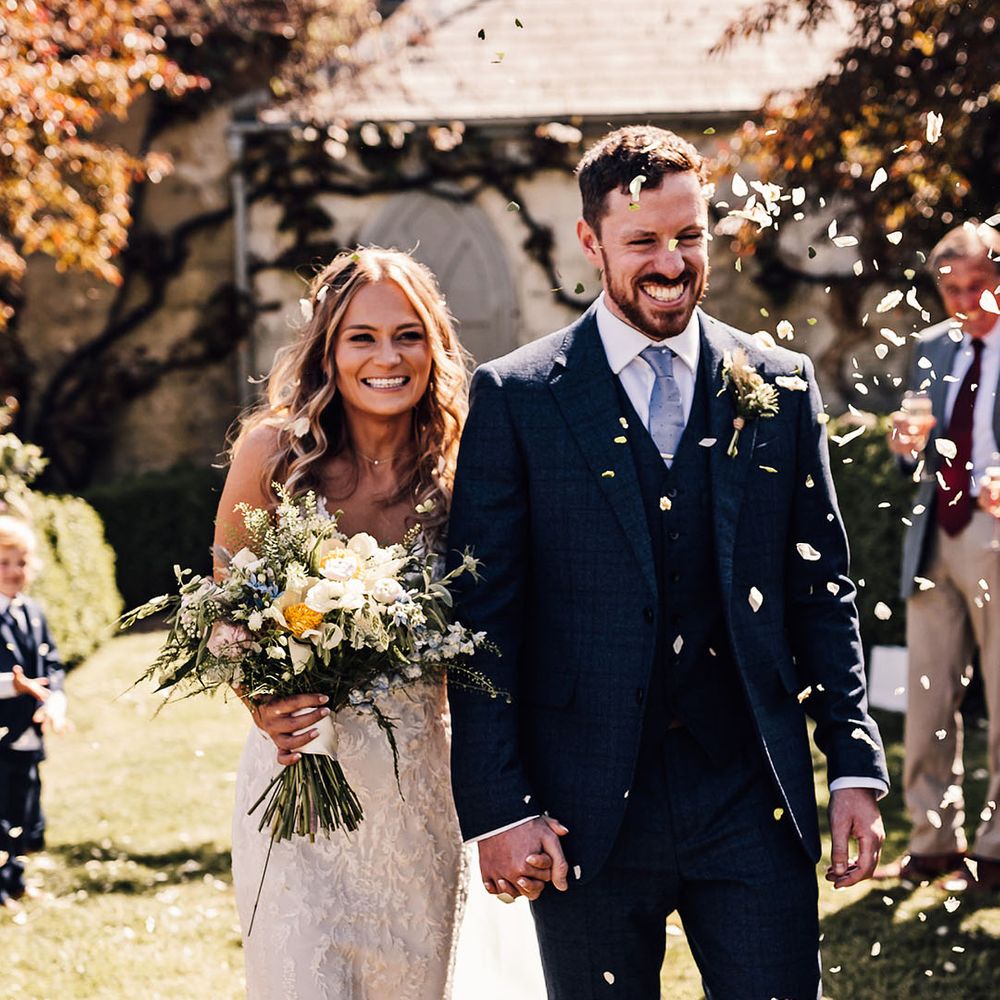 Bride and groom smile brightly as they have their confetti exit 