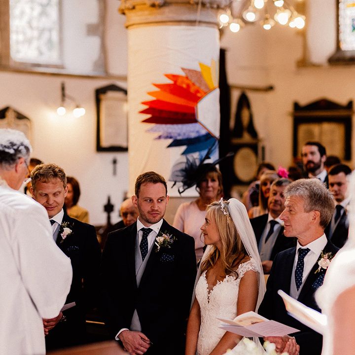 Bride and groom glance at each other during their church wedding ceremony 