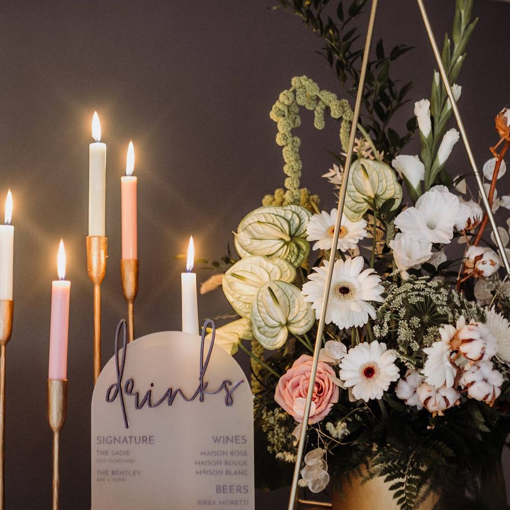 Acrylic drinks wedding sign and neutral coloured candelabra with white, pink and neutral floral bouquet