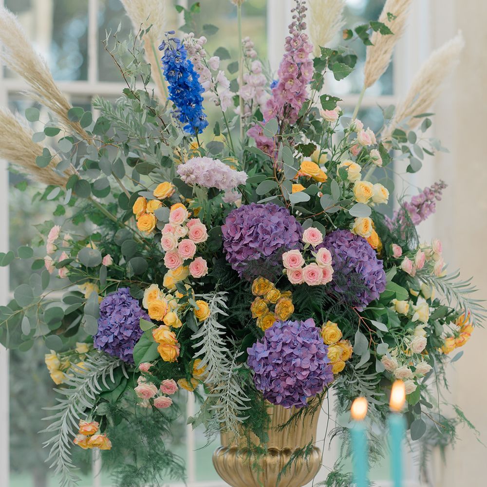 Colourful floral arrangement in gold vase 