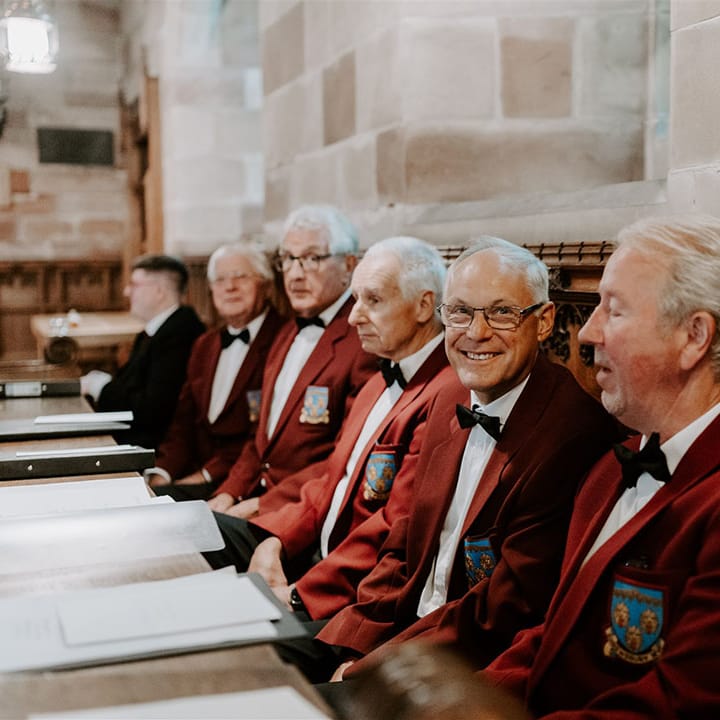 The choir all wearing matching maroon blazers with logo 