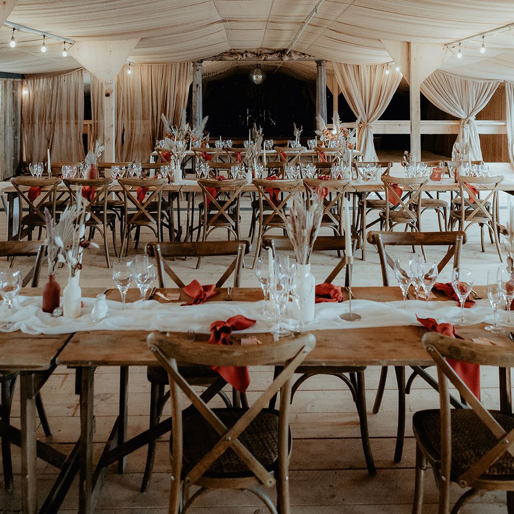 Unique wedding venue Rhyse Farm in Worcestershire with a white and burnt orange wedding tablescpae and bunny grass floral arrangements and disco balls 