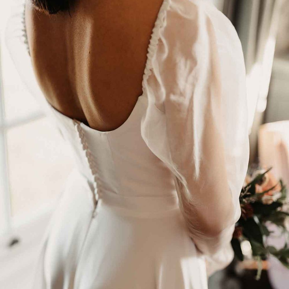 Bride in square neck puff sleeve wedding dress with button detailing on the back 