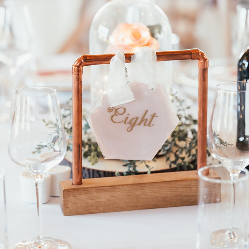 DIY Beauty and the Beast inspired rose wedding table centrepiece with the table number signage in front 