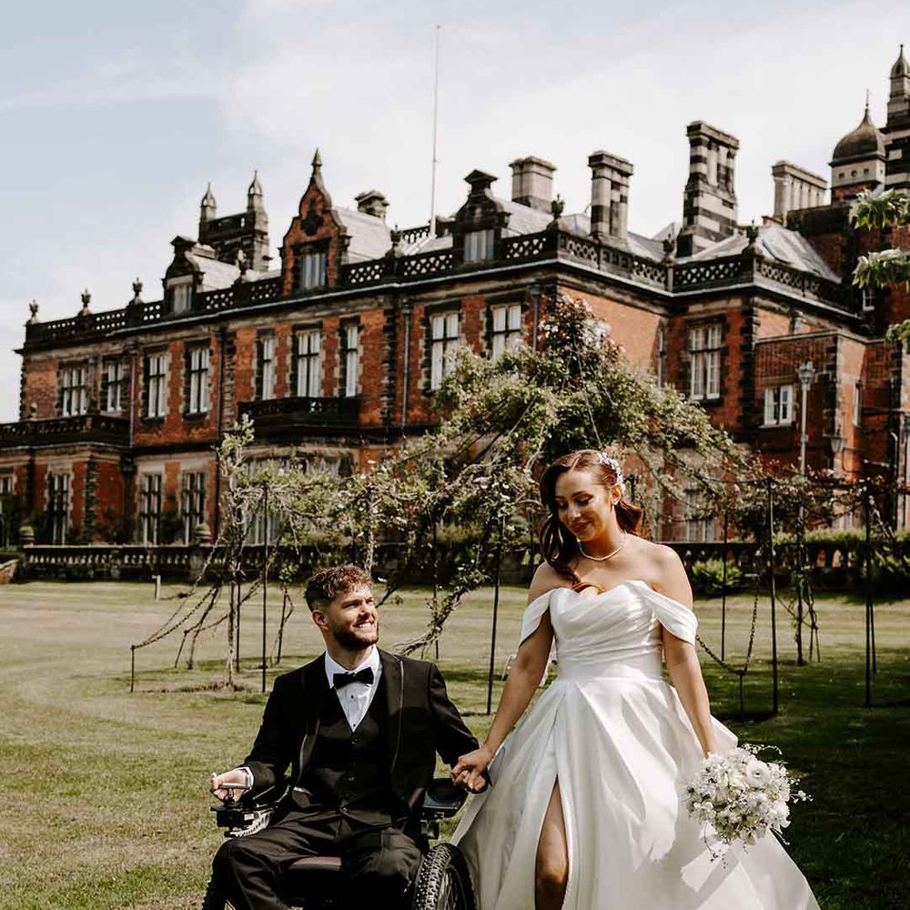 Interbred couple at country house wedding with tuxedo and princess wedding dress
