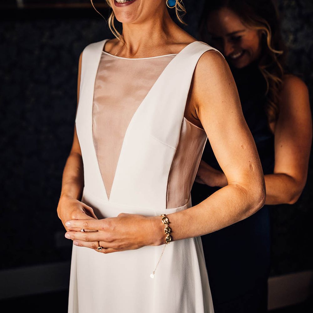 Bride with blonde hair in a braid crown hairstyle in an Andrea Hawke gown 