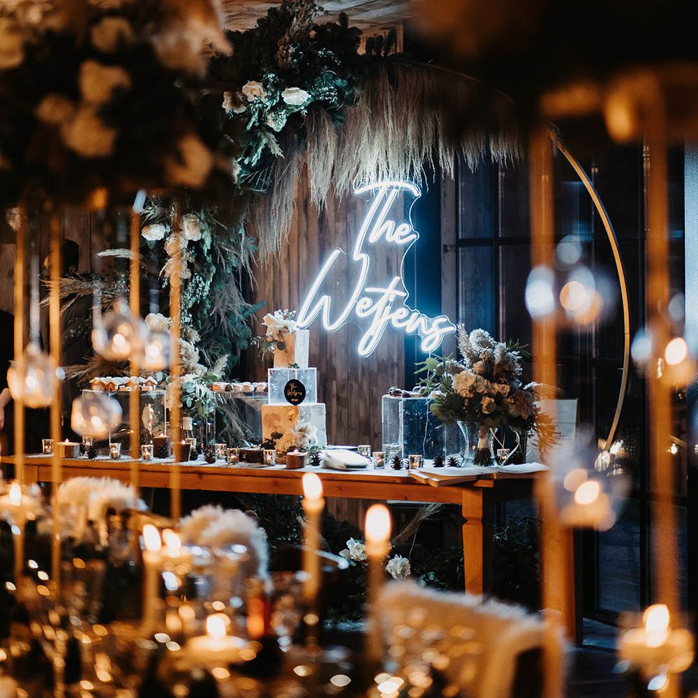 Bright white personalised neon sign and moongate as backdrop to the bride and groom on the top table 