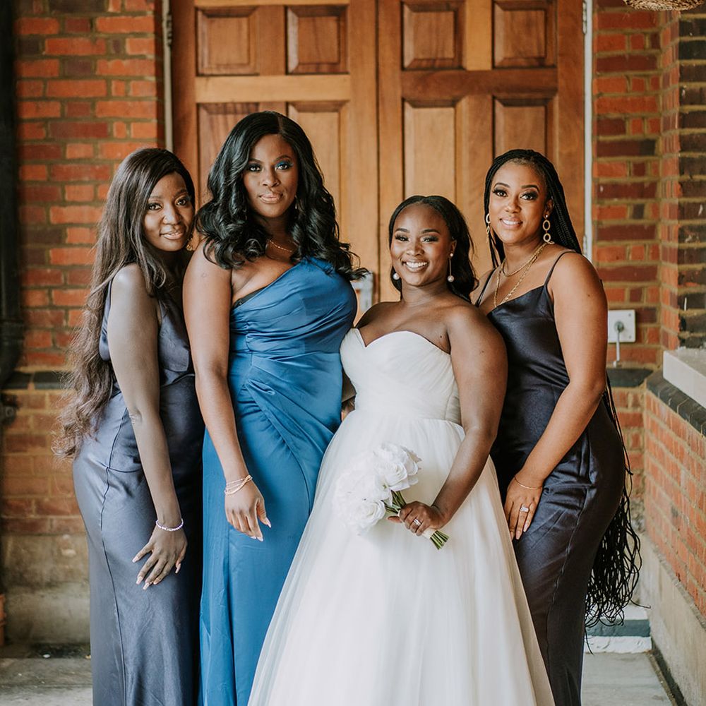 Bridal party wearing mismatched blue bridesmaid dresses in different shades 