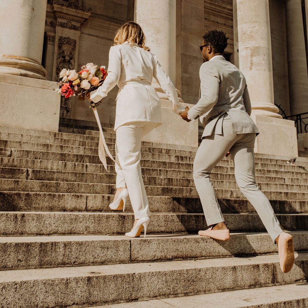 Stylish bride and groom walking up the steps of Portsmouth Guidhall
