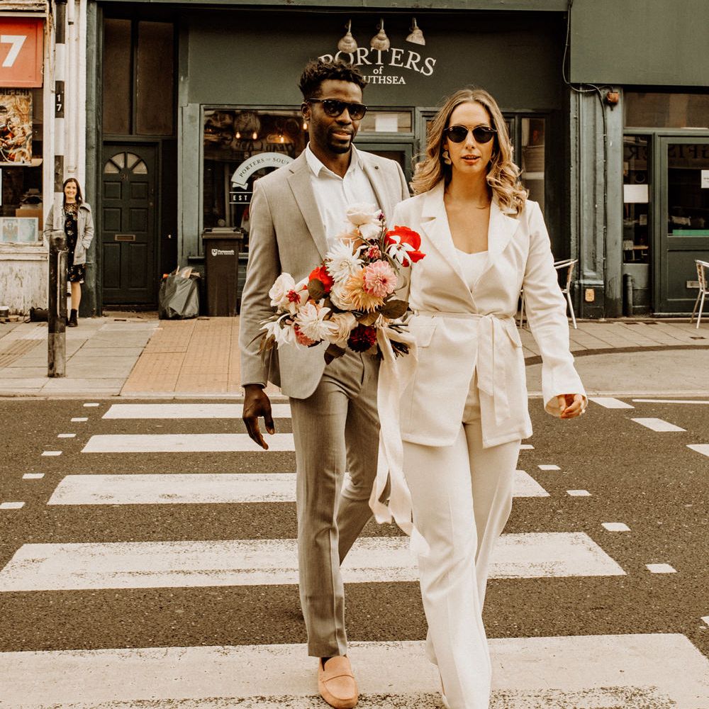 Stylish bride and groom crossing the street at Portsmouth city elopement 