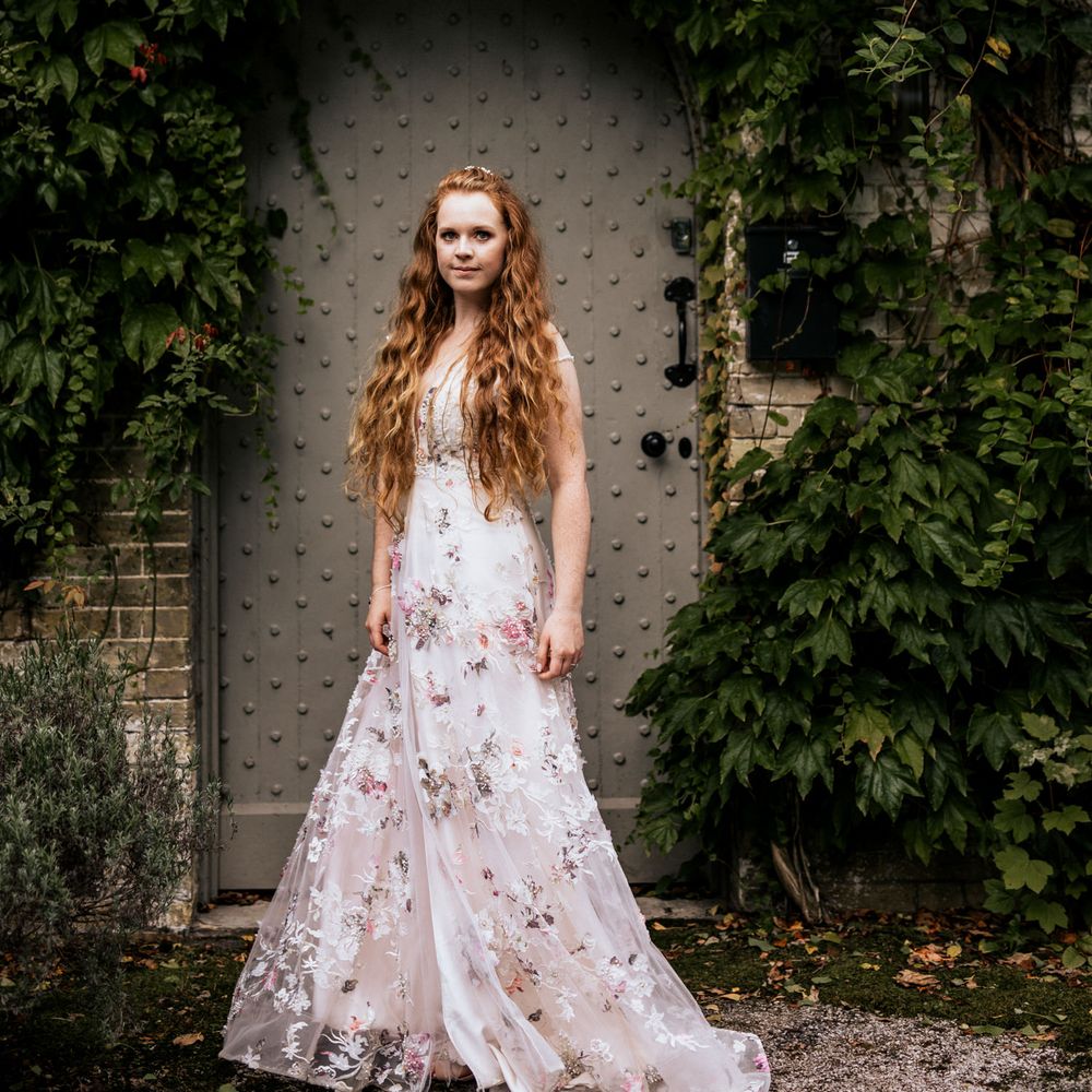 Bride poses in appliqué wedding dress with wavy hair 
