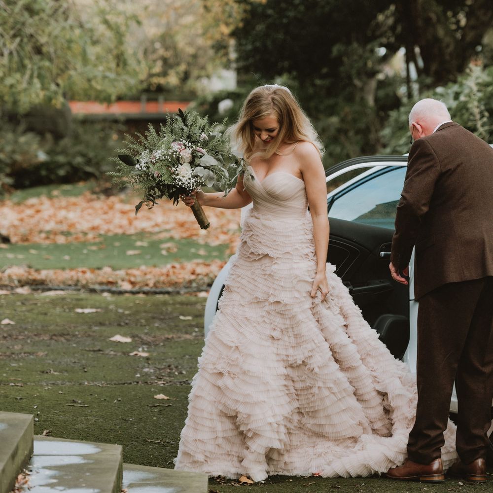 Bride arrives at church in pre loved wedding dress