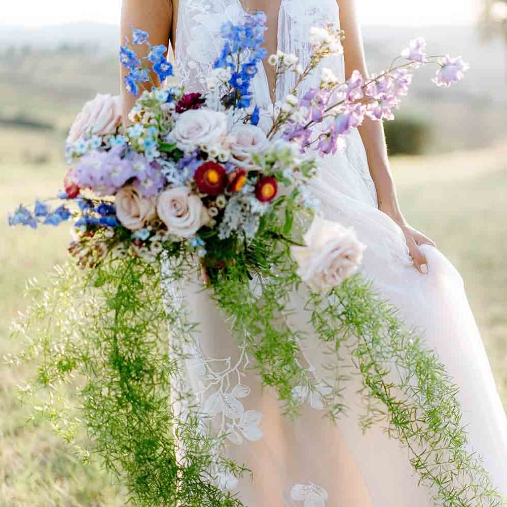 Stunning wedding bouquet with roses, foliage and wildflowers in pastel tones