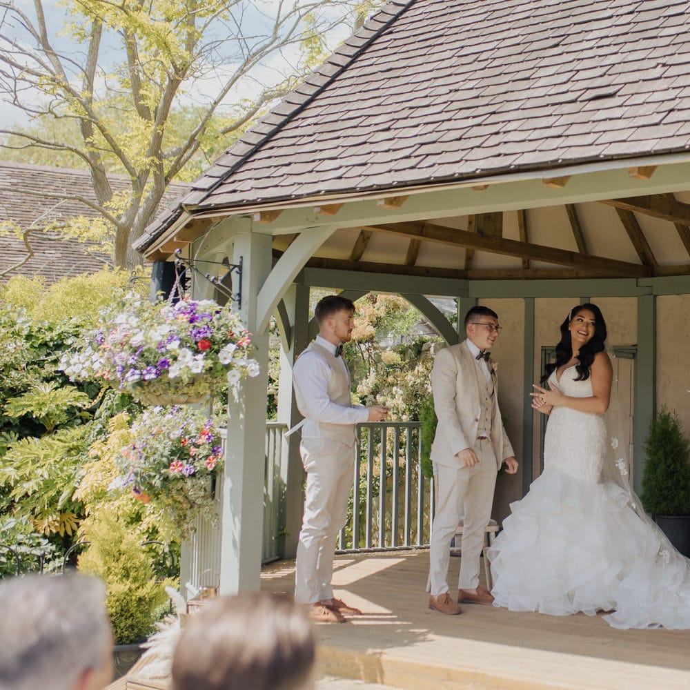 Bride and groom exchanging vows at their outdoor civil ceremony a Cooling Castle Barn wedding venue 