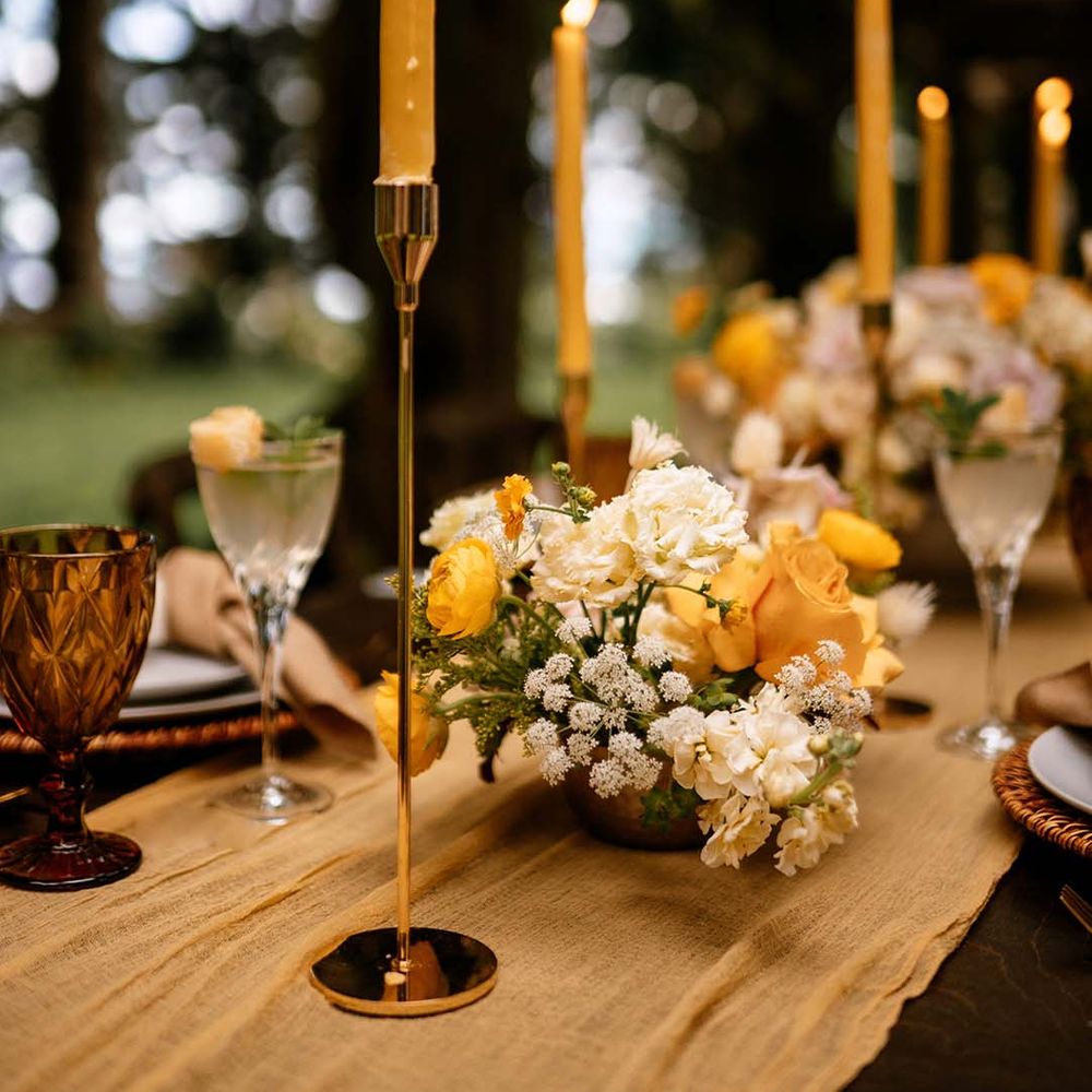 Honey yellow wedding inspiration with taper candles and floral arrangements 