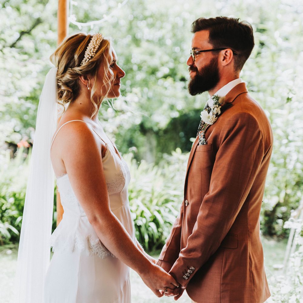 Bride & groom look into one another's eyes on their wedding day during ceremony as they marry and say their vows