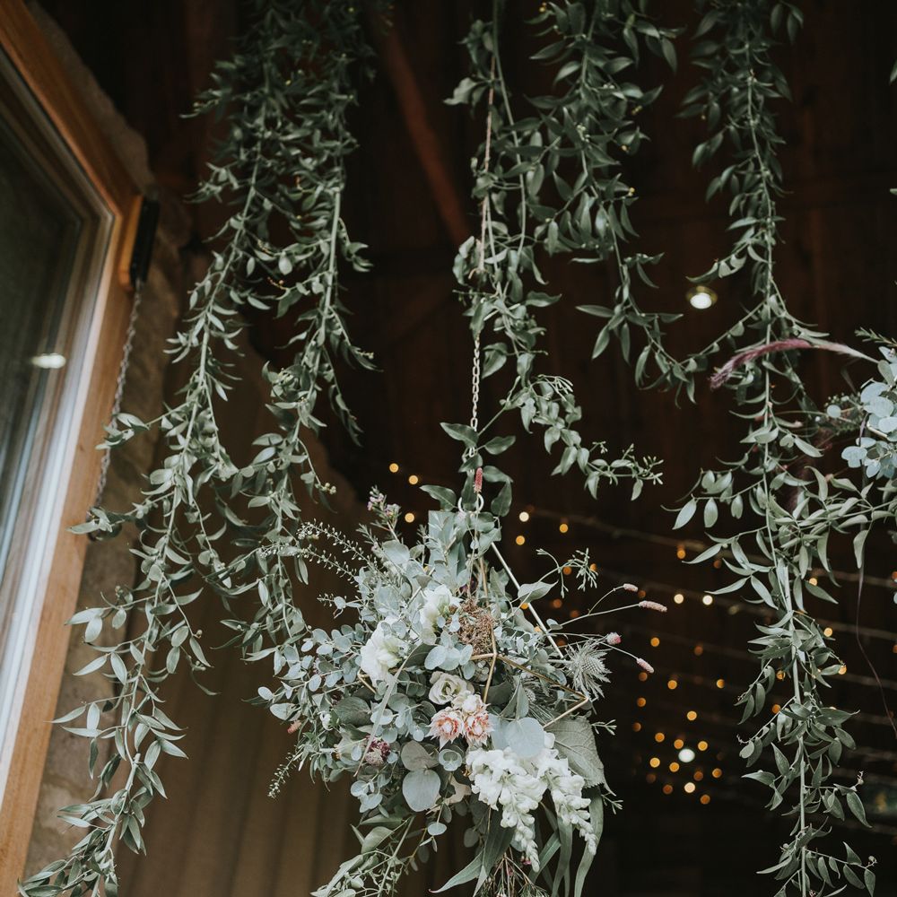 Hanging leaves and hanging flower bomb with pink proteas at Tythe Barn wedding