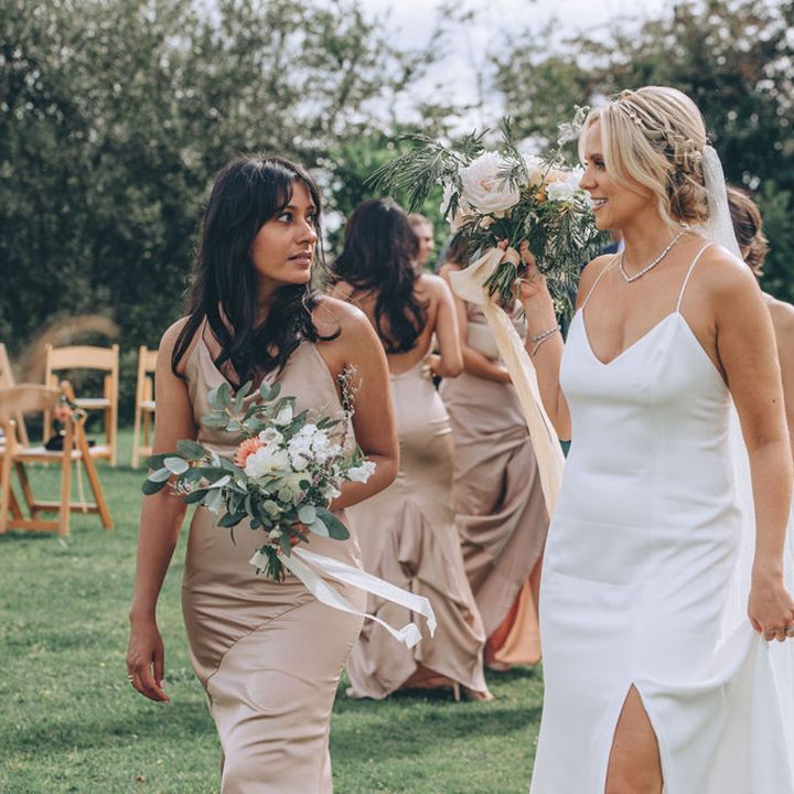 Bride in slip dress with pinned updo and pink bridesmaid dresses 