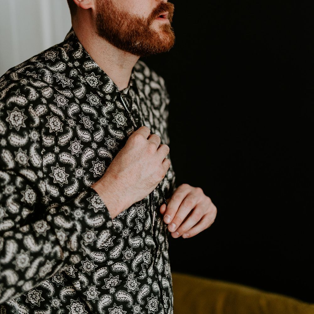 Groom does up his shirt on his wedding day