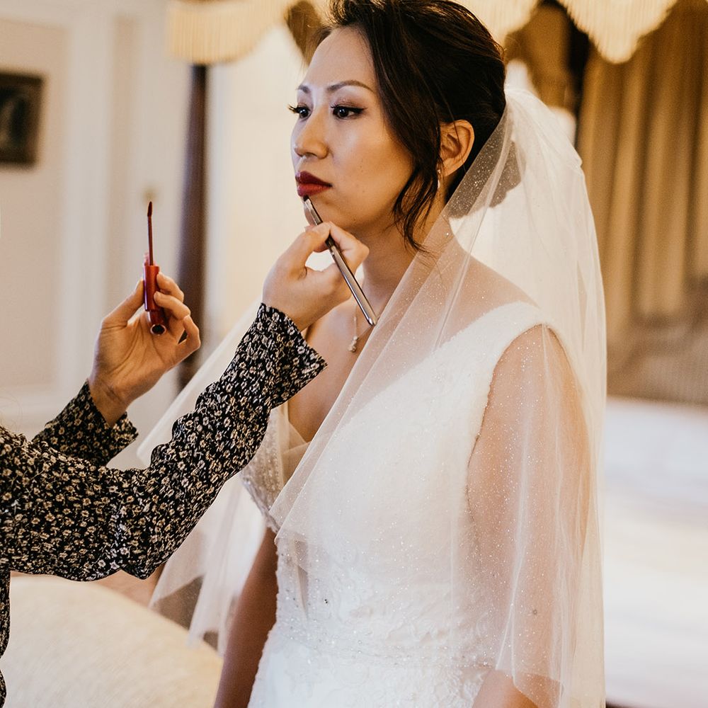 Bride gets makeup topped up before wedding