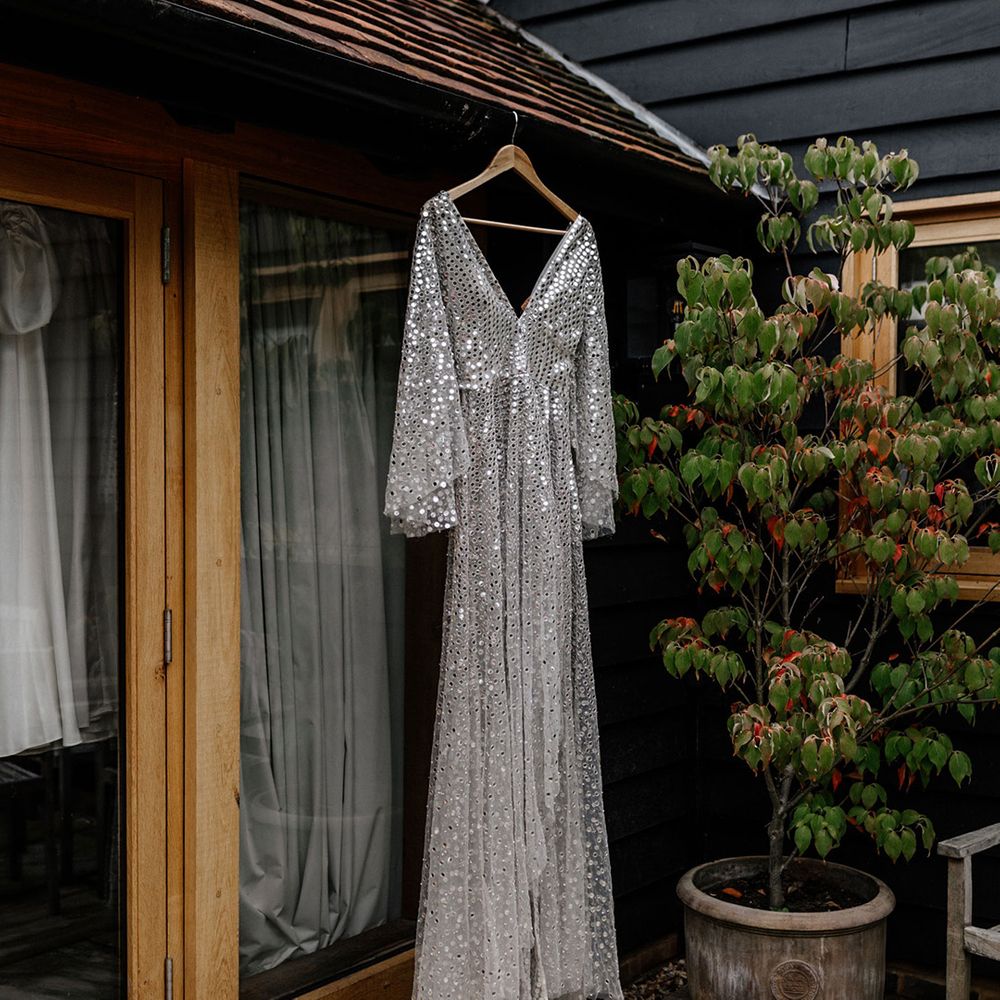 Silver, sequin, Chosen By Kyha wedding dress hanging up 