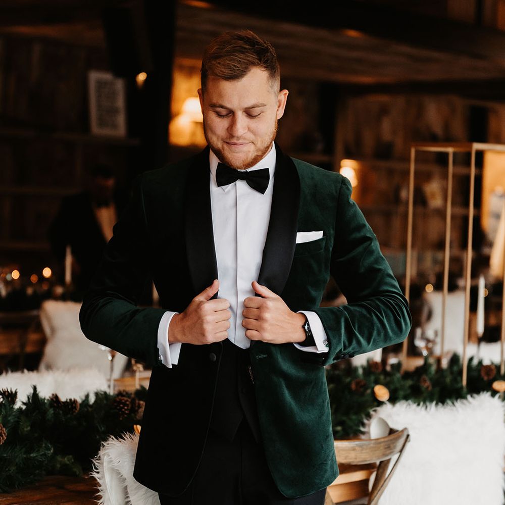 Groom in black tie for wedding including green velvet suit jacket