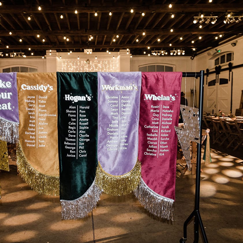 Fabric table plan with sparkly tassels, lightning bolts in purple, pink, green and gold fabric for 60s inspired wedding
