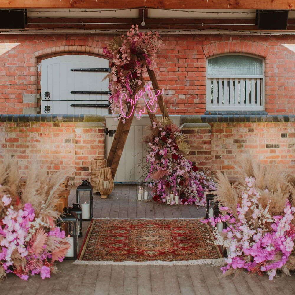 rustic barn wedding aisle decor with crazy in love neon sign, dried flowers and wooden benches