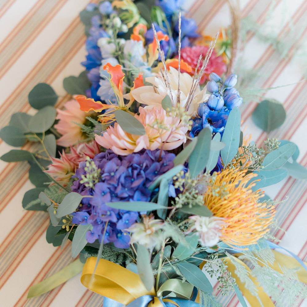 Colourful floral bouquet tied with yellow and blue silk ribbon 