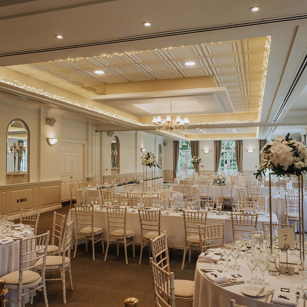 Classic white wedding tablescape with tall white flower centrepieces and table decor 
