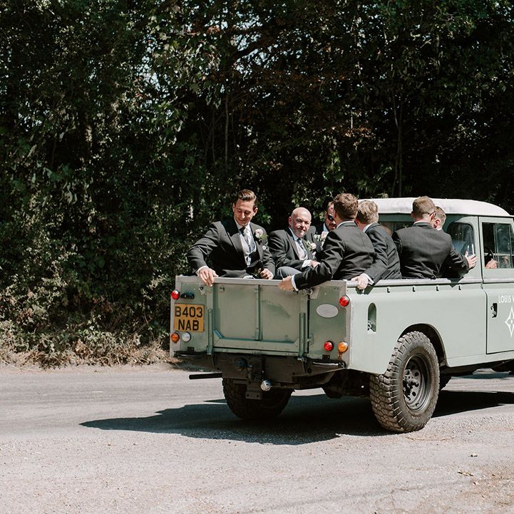 Groomsmen ride in sage green truck with a Louis Vuitton logo over to the reception 