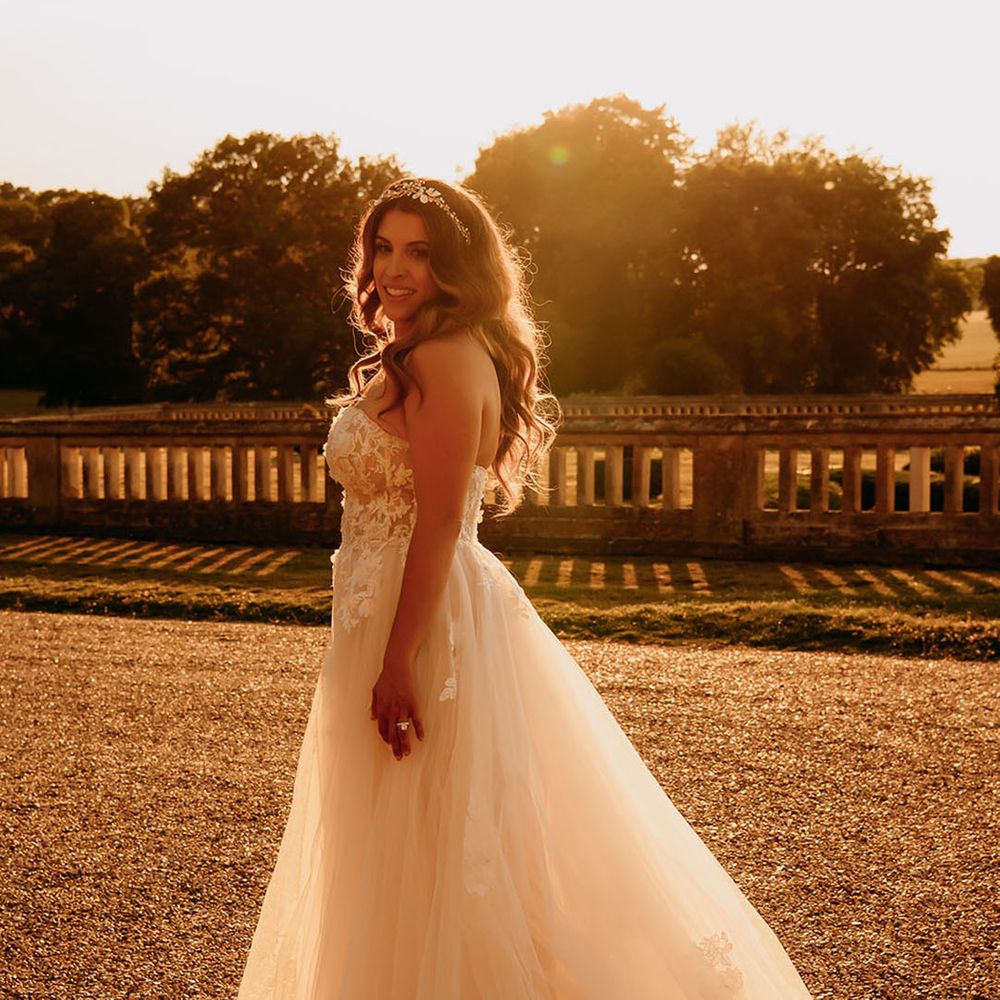 Gorgeous bridal portrait at sunset with the bride wearing a strapless corset style wedding dress with a tulle skirt and gold crown