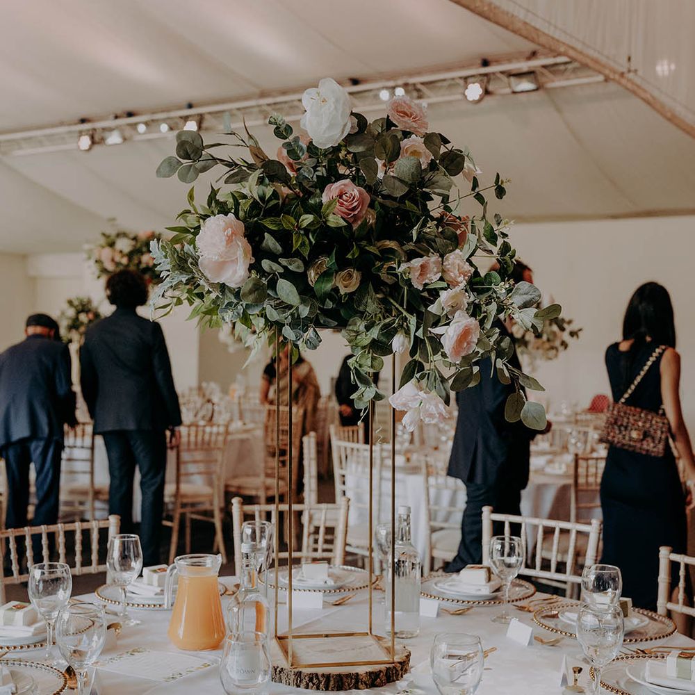Large floral arrangements complete with green foliage and pastel pink roses for classic tablescape at Braxted Park wedding venues Essex 
