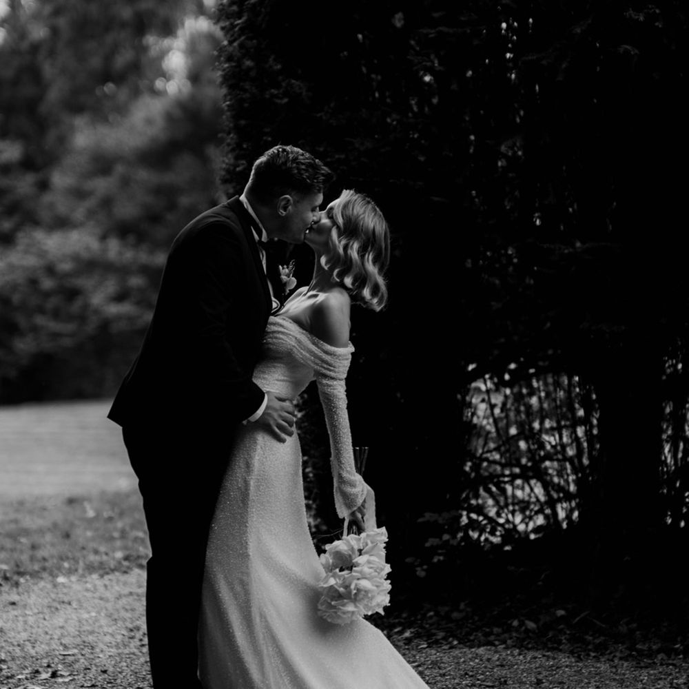 The groom leans in to kiss the bride in a sweeping kiss on their wedding day 