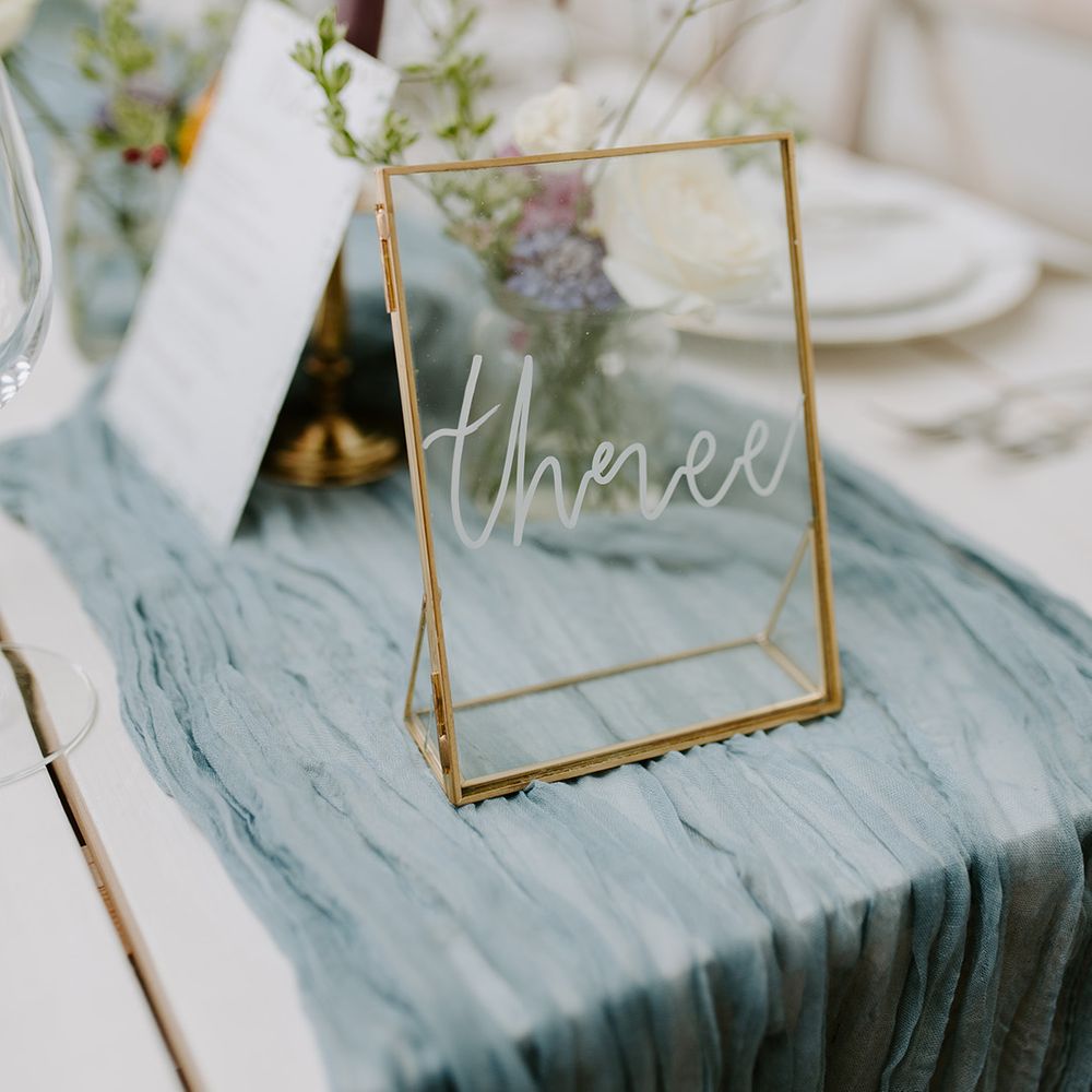 Sheer blue wedding table runner with clear gold photo frame with calligraphy for table name sign 