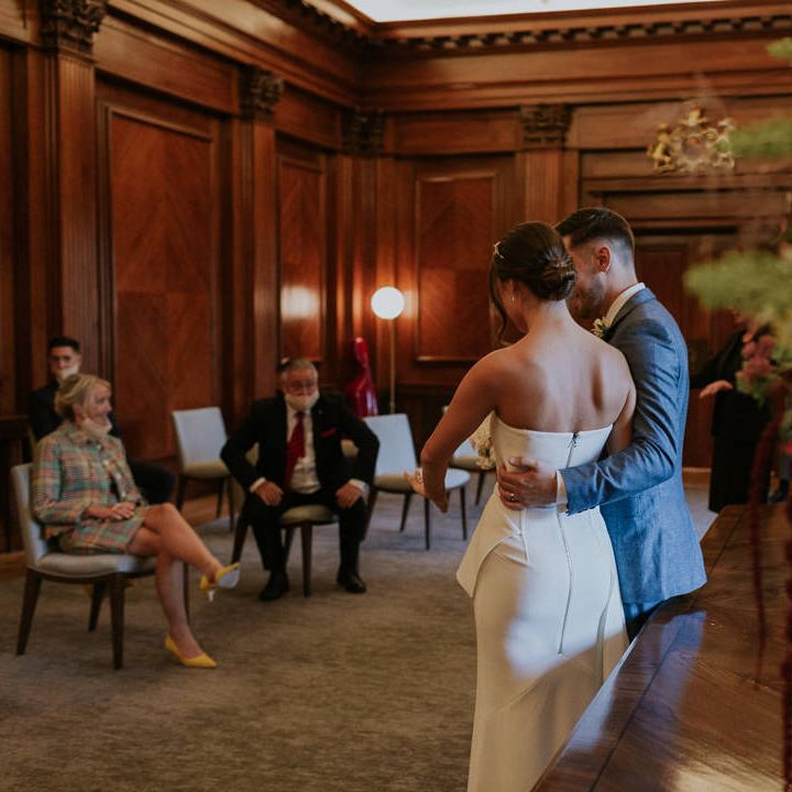 Groom embracing his bride at town hall micro wedding